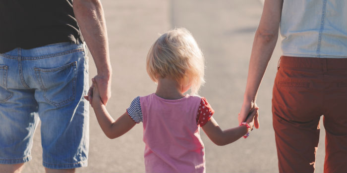 Child holding hands of parents