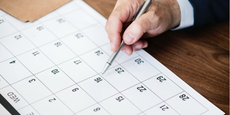 Person writing on calendar