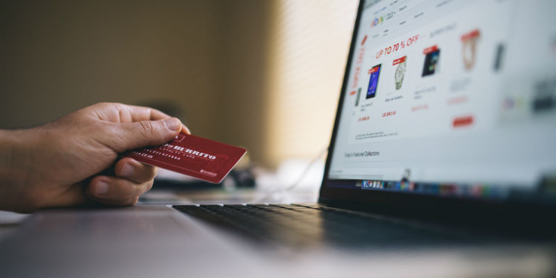 A person using their credit card to purchase products online