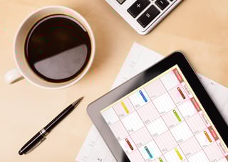Workplace with tablet pc showing calendar and a cup of coffee on a wooden work table close-up-1.jpeg